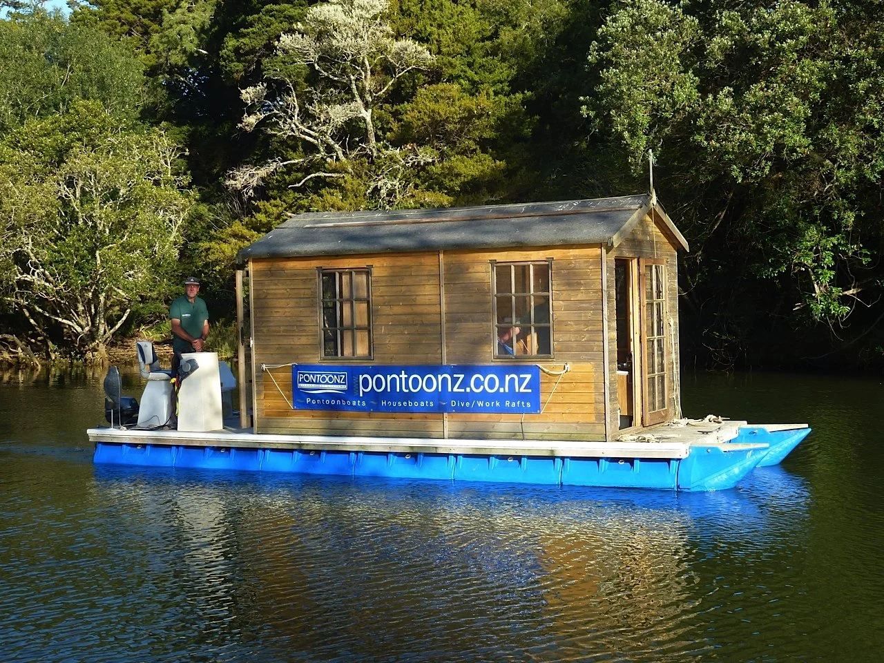 Cedar-clad Pontoonz houseboat moored on a bush-lined estuary