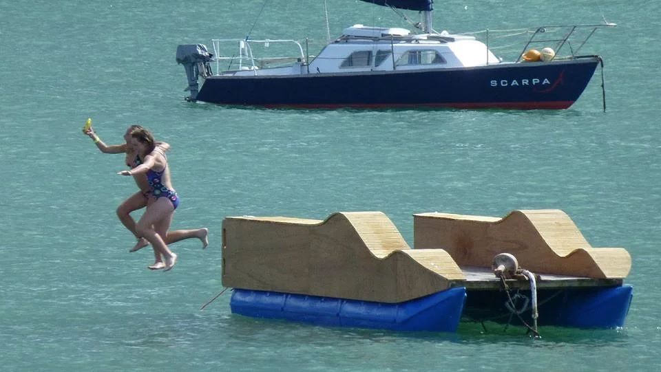 Child jumping off a small pod raft