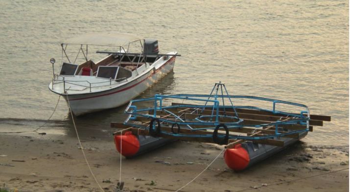 Mine detector barge on a riverbank