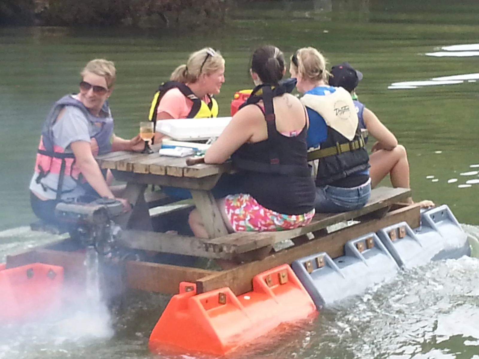 Friends at a picnic table on a pod raft