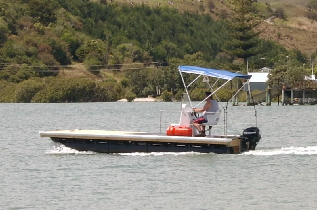 Flat-deck pontoon boat at speed