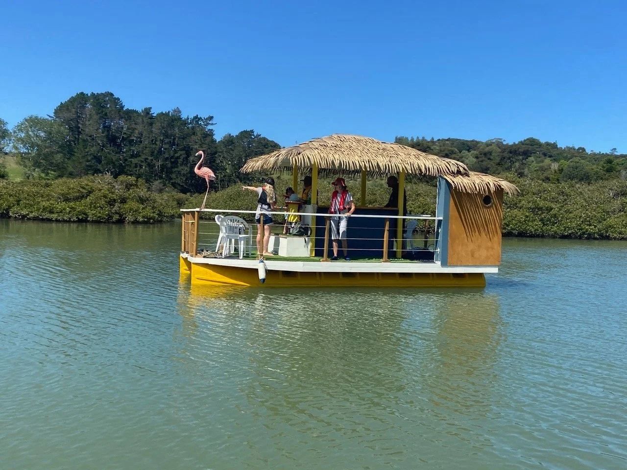 Thatched-roof tiki bar party boat on yellow Pontoonz pods